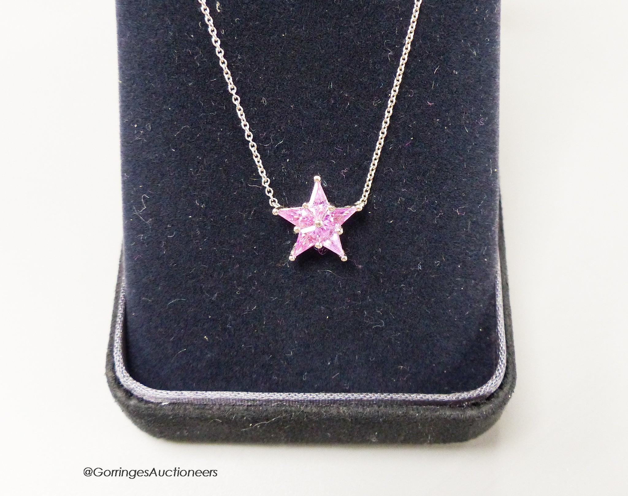 A modern Tiffany & Co platinum and five stone pink sapphire set star pendant necklace, star 11mm, gross weight 3.2 grams, in Tiffany & Co box, with original New York purchase receipt.